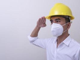 Asian industrial workers wear yellow hard hats, wear protective masks for their health photo