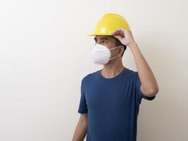 Asian industrial workers wear yellow hard hats, wear protective masks for their health photo