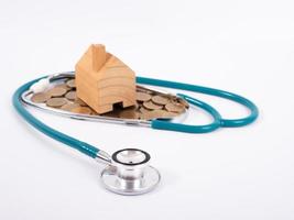 Check up house and investment concept. Stethoscope with miniature house and money photo