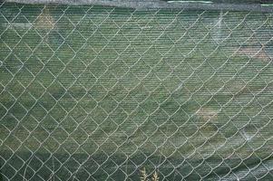 Installation of a shading net on a chain-link fence photo