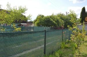 Installation of a shading net on a chain-link fence photo
