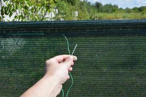 Installation of a shading net on a chain-link fence photo