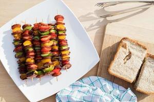 Skewers with sausage and vegetables on the table, top view, barbecue concept
