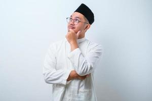 Asian muslim man doing thinking gestire, looking for idea photo