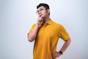 Adult Asian man wearing yellow flannel shirt showing thinking gesture photo