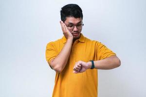 Handsome asian an wearing casual clothes looking at the watch time worried, afraid of getting late photo