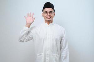 Asian muslim man wearing casual clothes showing and pointing up with fingers number five while smiling confident and happy photo