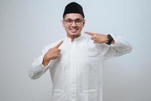 Asian muslim man smiling confident showing and pointing with fingers teeth and mouth. Health concept. photo