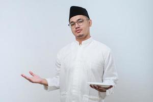 Asian muslim man showing disappointed expression while showing empty dinner plate photo