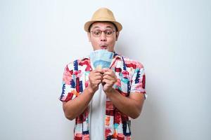 Young Asian man showing excited face expression while holding money photo