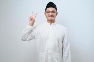 Asian muslim man wearing casual clothes showing and pointing up with fingers number two while smiling confident and happy photo