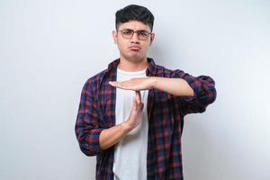 Young handsome man doing time out gesture with hands, frustrated and serious face photo