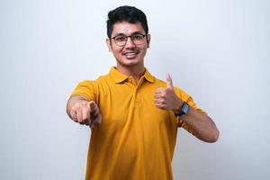 Adult Asian man pointing forward while giving thumb up photo