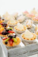 Variety of tasty appetizing sweet desserts with cream, berries and pastry, bakery and cakes on the grand wedding table at celebrate photo