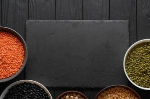 Legumes, overhead flat lay shot on a dark rustic wooden background with a place for text photo