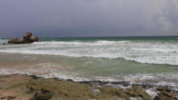 fantastisk klippkust. havsvågor slår stenigt på stranden. strand med vågor på ett grovt hav. full hd-video video