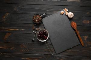 Dark cooking banner. Vegetables and spices on the kitchen table. Top view. Free space for your text. photo