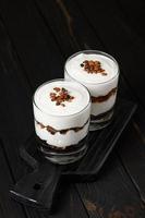 Greek yogurt with granola on a wooden dark wooden background. photo