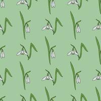 Seamless pattern with stylish snowdrops on light green background. Vector image.