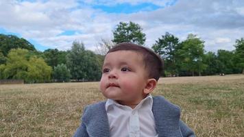 schattige kleine baby baby poseert in een plaatselijk openbaar park in de stad Luton in Engeland video