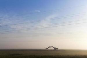 Excavator in a fog photo