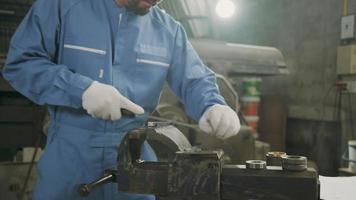 un lavoratore professionista asiatico maschio ingegnere industriale lavora in uniforme di sicurezza con strumenti di precisione per la lavorazione dei metalli, macchine per tornio meccanico e officina di pezzi di ricambio nella fabbrica di produzione dell'acciaio. video