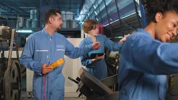 Multiracial professional industry engineer teams in safety uniforms work by inspecting machines' voltage current, checking, and maintaining at manufacture factory, electric system service occupations. video