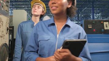 Multiracial professional industry engineer teams in hard hats and safety uniforms inspect machine control panels, check, and maintain at mechanical manufacture factory, electrical service occupations. video