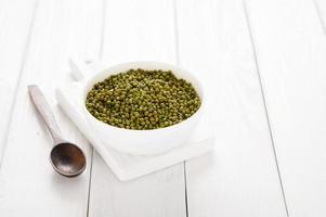 Mung bean in a white plate on a white wooden background photo
