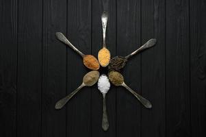 Colorful various herbs and spices for cooking on dark wooden rustic background photo