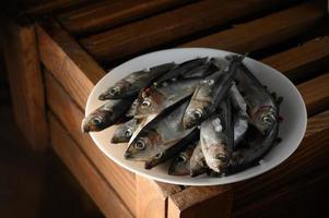 Fresh sardines on rustic wooden background. photo