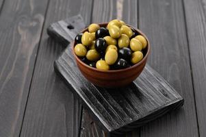 Black and green olives on a dark wooden rustic background. photo