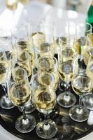 A lot of wine glasses with a cool delicious champagne or white wine at the bar. Alcohol background. photo