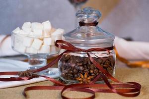 Glass jar with coffee beans decorated with ribbon photo