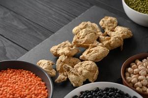 Soy meat and legumes, overhead flat lay shot on a dark rustic wooden background photo