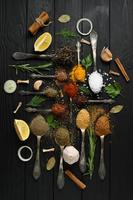 Colorful various herbs and spices for cooking on dark wooden rustic background photo