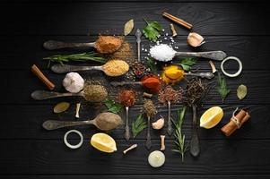 Colorful various herbs and spices for cooking on dark wooden rustic background photo