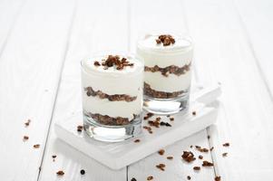 Dessert with mascarpone cheese and granola on a white wooden background. photo