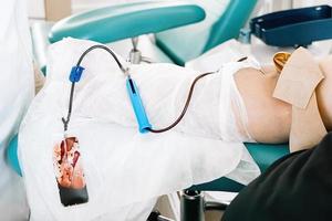 día internacional de la donación de sangre. hombre dona sangre en laboratorio médico. foto