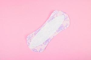 toalla sanitaria sobre fondo rosa. producto de higiene femenina diaria. concepto de menstruación. foto
