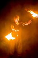 Fire show on the open air festival. Artists exhale flame, pillar of fire on a black background - July 8, 2015, Russia, Tver. photo
