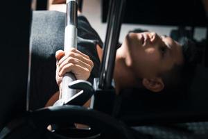 man exercising with barbell, weight training building body strength At the gym in the morning sun. photo