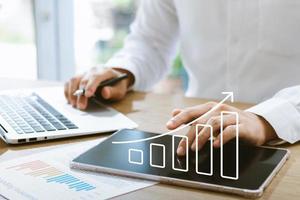 Businessman analyzing company's financial balance sheet working with digital augmented reality graphics. Businessman calculates financial data for long-term investment. photo