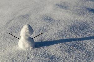 one small snowman in the winter season, close up photo