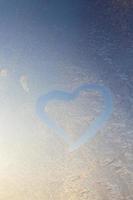 heart painted in winter on frozen glass, close up photo