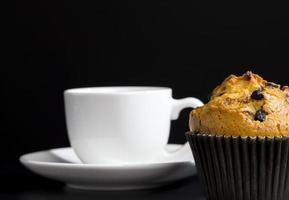 a delicious fresh bun and a cup of black aromatic coffee photo