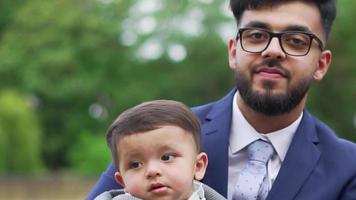 Asian Pakistani Father is holding his 11 Months Old Infant at Local Park
