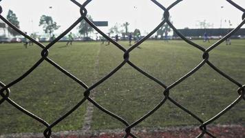 jugadores de fútbol entrenando detrás de una valla de metal vieja y oxidada video
