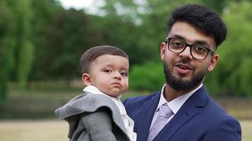 Der asiatische pakistanische Vater hält sein 11 Monate altes Kind im örtlichen Park video