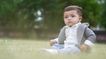 Mignon petit bébé bébé pose dans un parc public local de la ville de Luton en Angleterre Royaume-Uni video